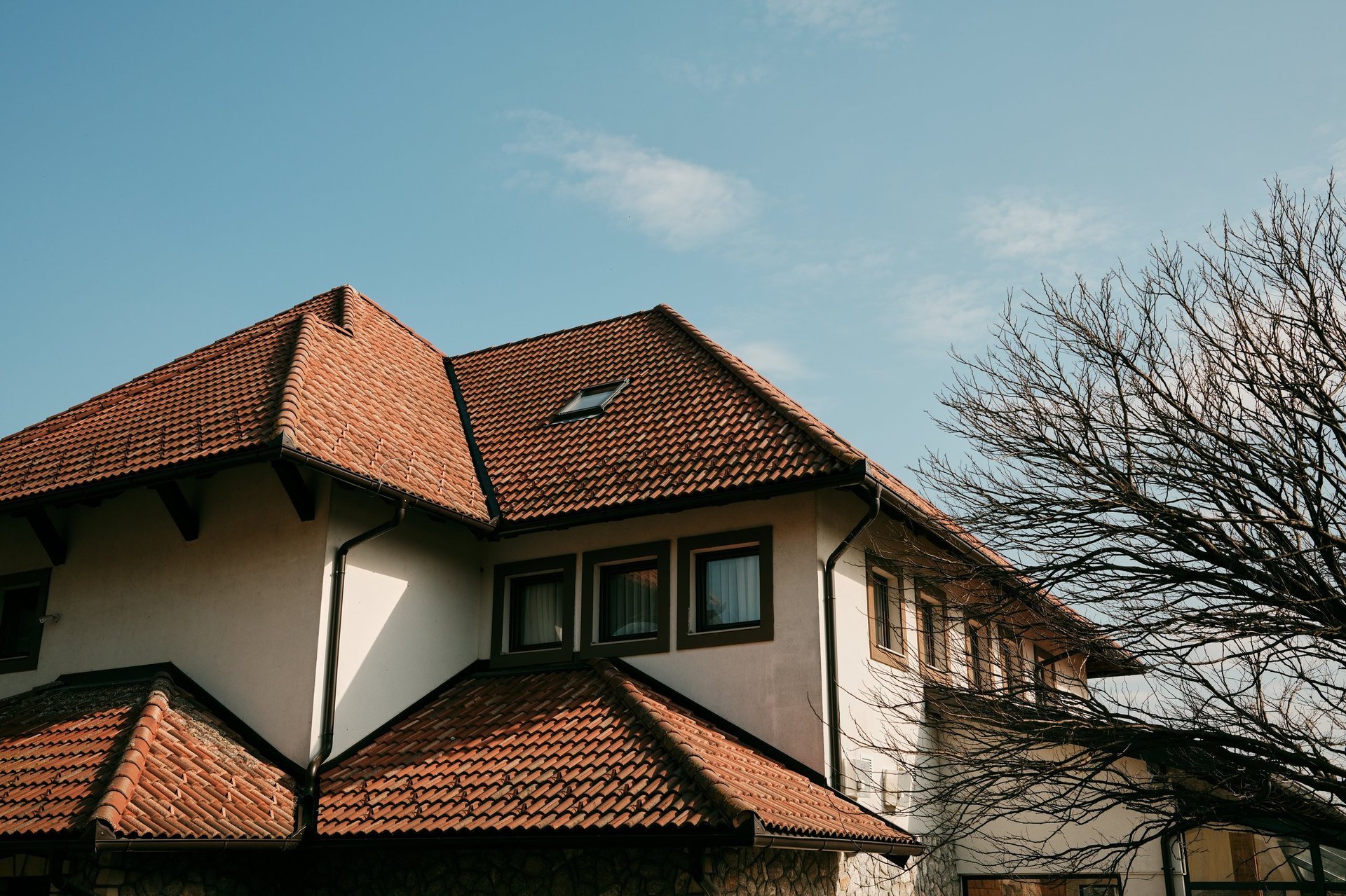 Residential building with traditional terracotta tile roof under blue sky