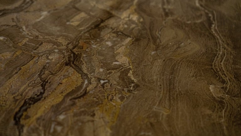 Close-up of natural stone or marble surface with swirling brown and tan veining patterns and texture