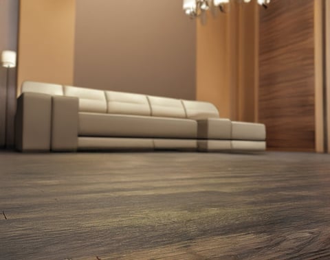 Modern beige sectional sofa in minimalist living room with wooden flooring and warm lighting